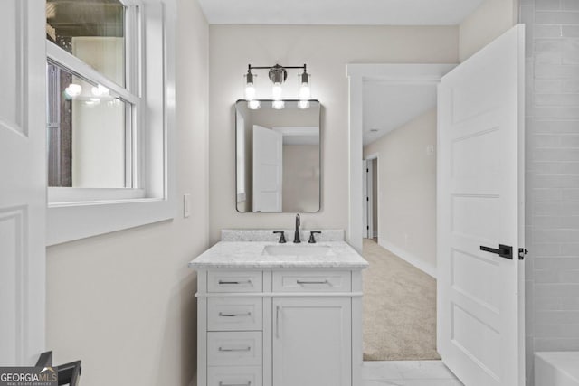 full bathroom featuring a bathing tub, vanity, marble finish floor, and baseboards