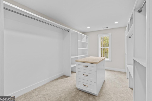 spacious closet with visible vents and light colored carpet