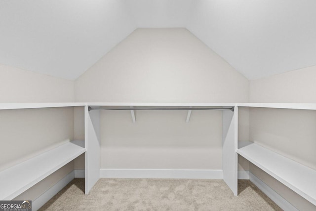 walk in closet featuring carpet floors and lofted ceiling