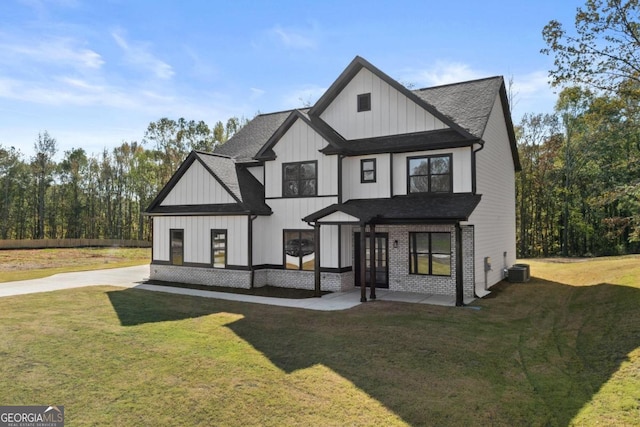 exterior space with a lawn, board and batten siding, central AC, and roof with shingles