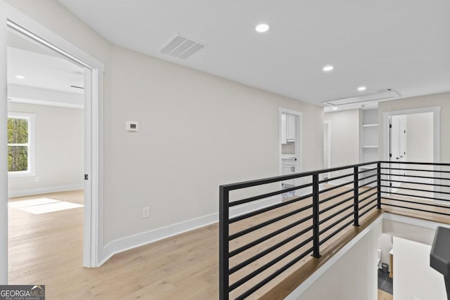 hallway featuring recessed lighting, light wood-style floors, an upstairs landing, baseboards, and visible vents