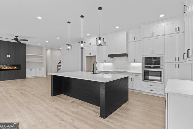 kitchen featuring black electric cooktop, ceiling fan, white cabinets, and stainless steel oven