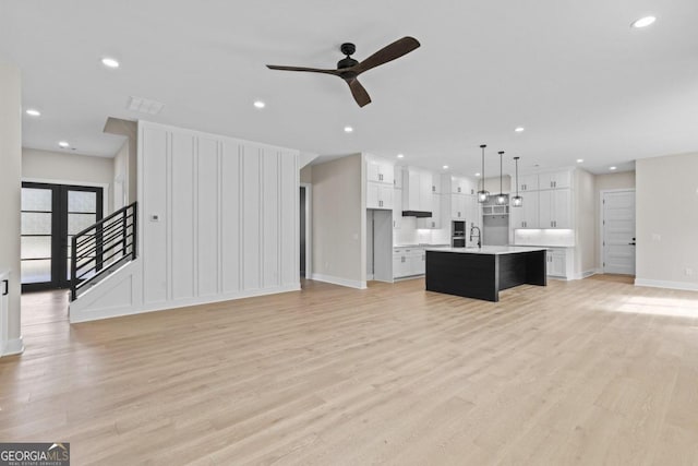 unfurnished living room with recessed lighting, a ceiling fan, light wood-style floors, and baseboards