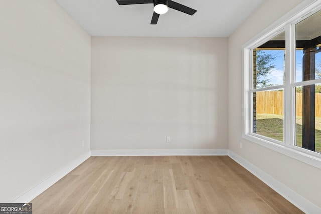 empty room featuring baseboards, light wood-type flooring, and a ceiling fan
