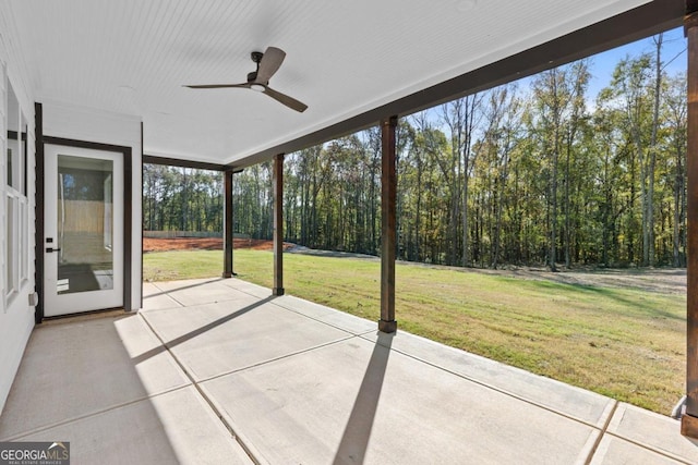 unfurnished sunroom featuring a ceiling fan and a healthy amount of sunlight