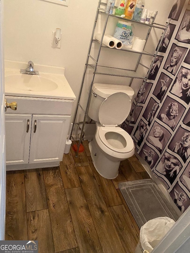 bathroom with vanity, wood finished floors, and toilet