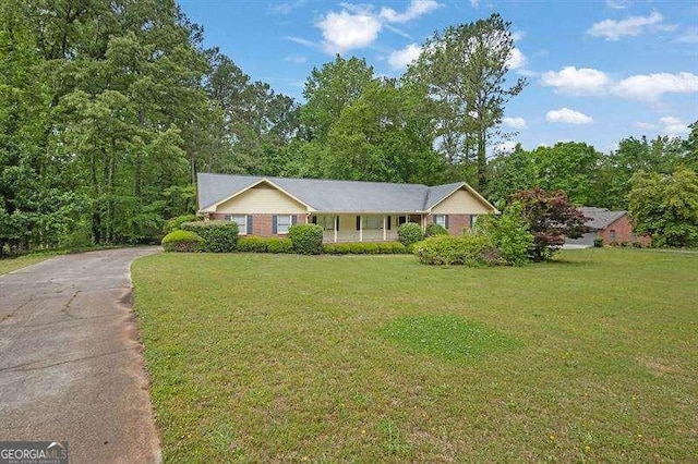 single story home with covered porch, a front lawn, and driveway