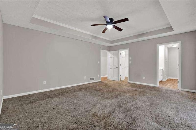 unfurnished bedroom featuring visible vents, carpet floors, a raised ceiling, and baseboards