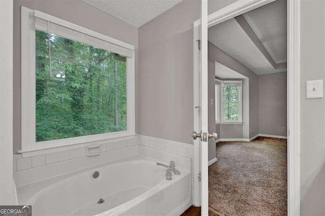 bathroom featuring a garden tub and baseboards