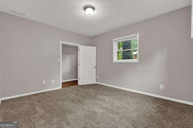 carpeted spare room with baseboards and a textured ceiling