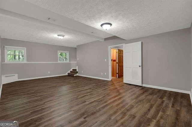 below grade area with a textured ceiling, wood finished floors, and baseboards