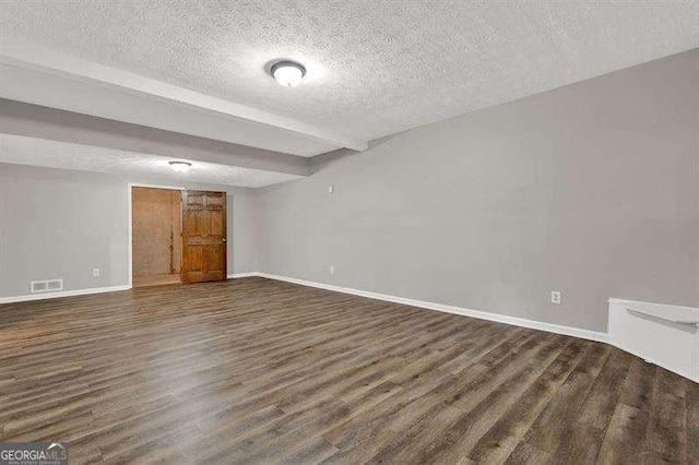 finished basement with baseboards, visible vents, and a textured ceiling