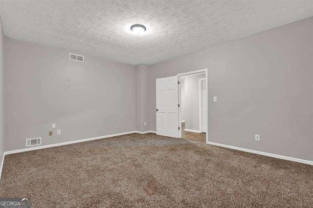 unfurnished room featuring carpet, visible vents, and baseboards