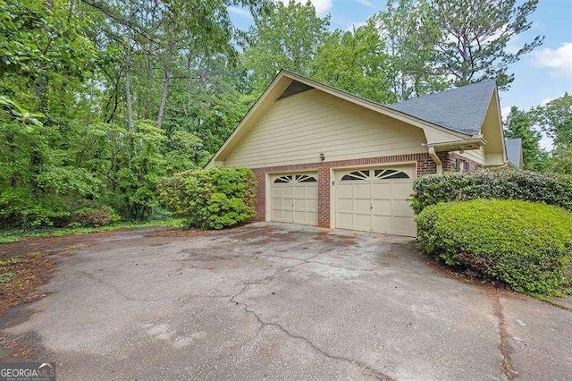 view of side of property with an attached garage and brick siding