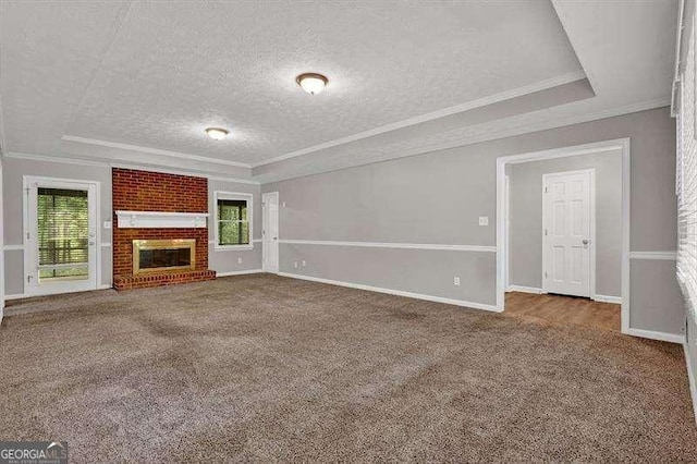 unfurnished living room featuring a fireplace, a textured ceiling, ornamental molding, and carpet floors