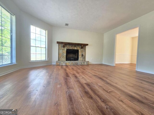 5229 Mountain Village Ct, Stone Mountain, GA 30083 - unfurnished living room featuring a fireplace, visible vents, wood finished floors, and baseboards