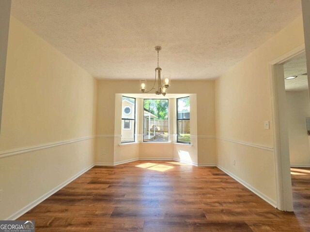 5229 Mountain Village Ct, Stone Mountain, GA 30083 - unfurnished dining area featuring a textured ceiling, an inviting chandelier, wood finished floors, and baseboards