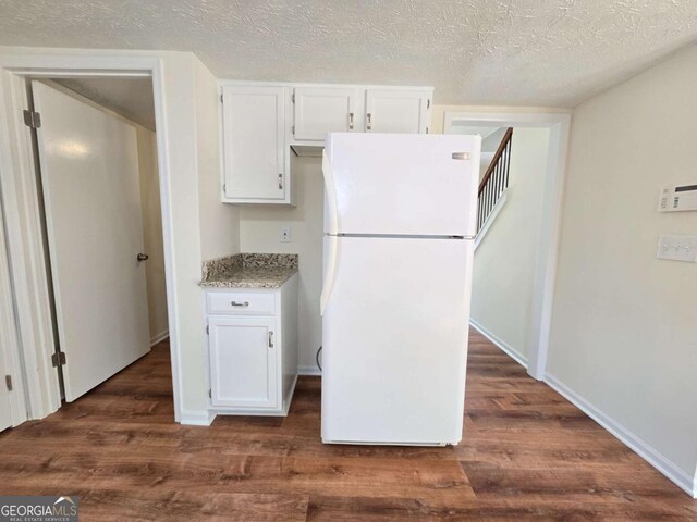 5229 Mountain Village Ct, Stone Mountain, GA 30083 - kitchen featuring white cabinetry, freestanding refrigerator, baseboards, light stone countertops, and dark wood-type flooring