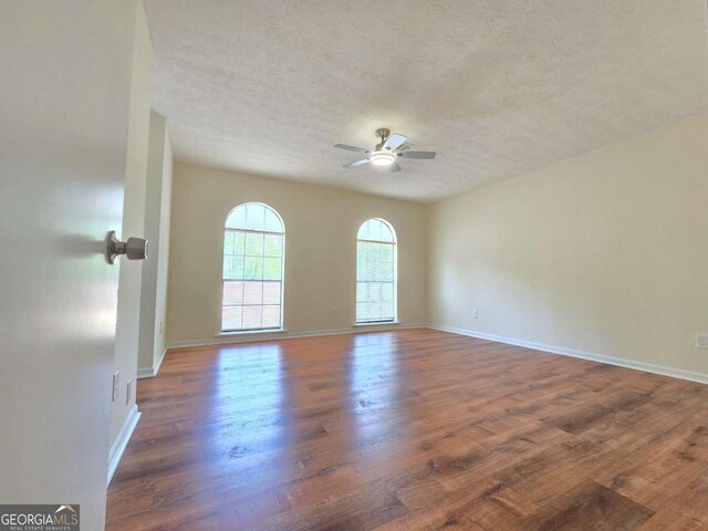 5229 Mountain Village Ct, Stone Mountain, GA 30083 - spare room with a ceiling fan, baseboards, wood finished floors, and a textured ceiling