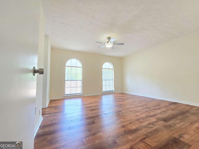 5229 Mountain Village Ct, Stone Mountain, GA 30083 - unfurnished room with baseboards, wood finished floors, a ceiling fan, and a textured ceiling
