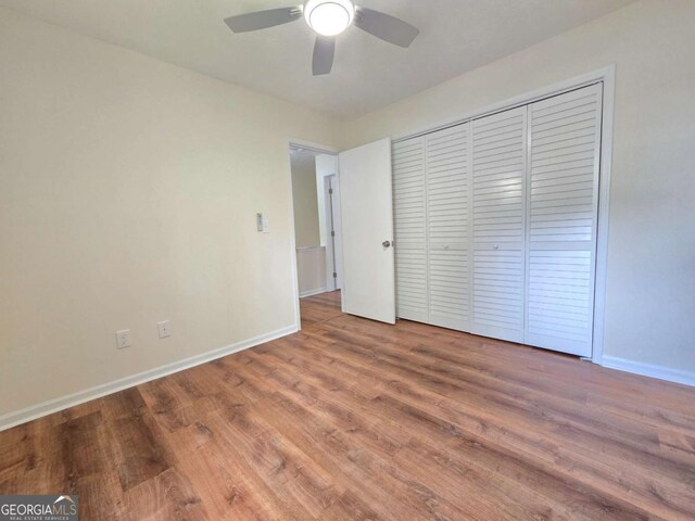 5229 Mountain Village Ct, Stone Mountain, GA 30083 - unfurnished bedroom featuring baseboards, wood finished floors, ceiling fan, and a closet