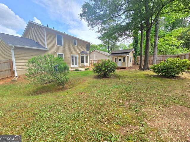 5229 Mountain Village Ct, Stone Mountain, GA 30083 - back of house featuring an outbuilding, a lawn, a storage unit, and fence