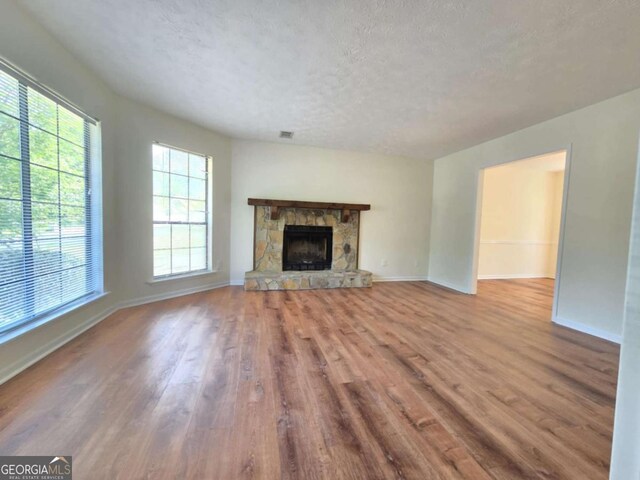 5229 Mountain Village Ct, Stone Mountain, GA 30083 - unfurnished living room featuring a textured ceiling, wood finished floors, plenty of natural light, and baseboards