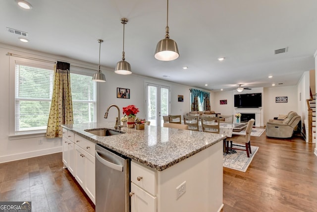 kitchen featuring dishwasher, a sink, white cabinets, and visible vents
