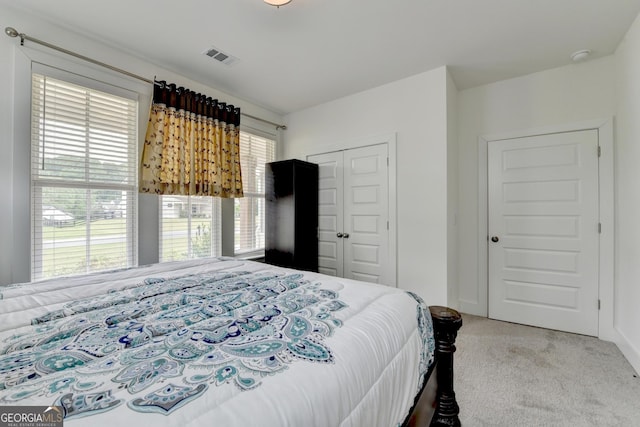 carpeted bedroom featuring visible vents and a closet