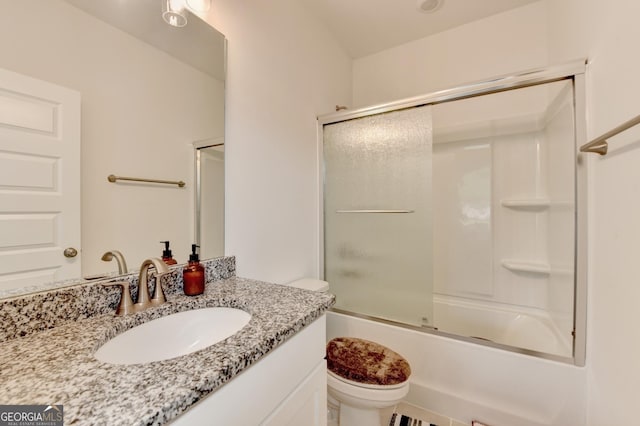 bathroom featuring bath / shower combo with glass door, toilet, and vanity