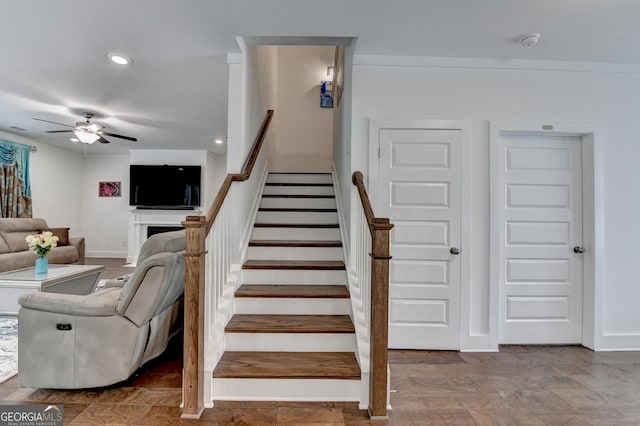 stairway with a fireplace, recessed lighting, ceiling fan, and baseboards