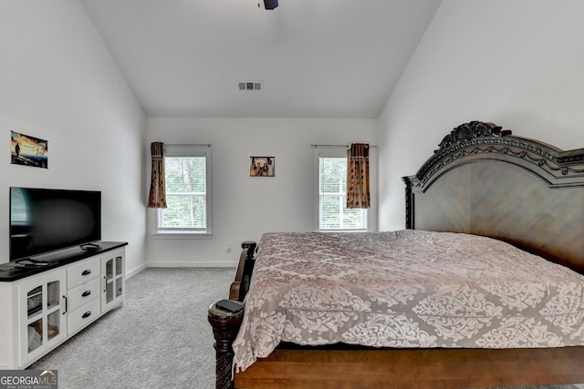 bedroom with multiple windows, visible vents, vaulted ceiling, and carpet floors