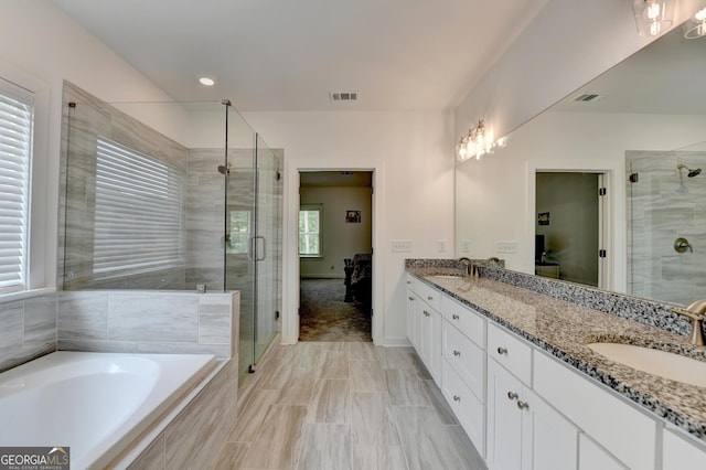 full bath with a stall shower, double vanity, a sink, and visible vents