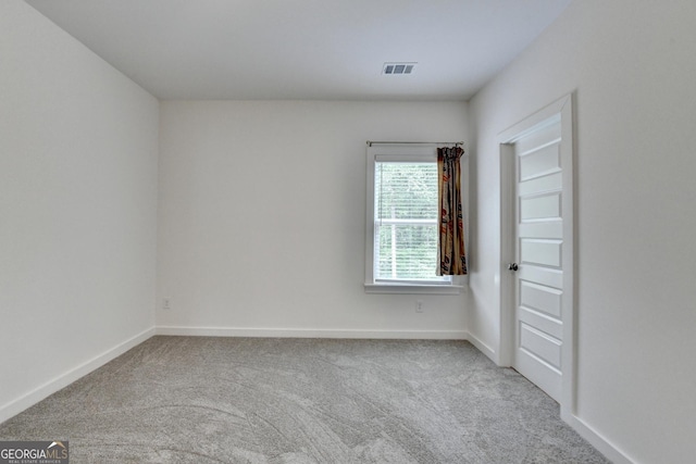 empty room with visible vents, carpet, and baseboards