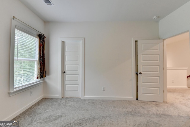 unfurnished bedroom featuring carpet flooring, visible vents, and baseboards
