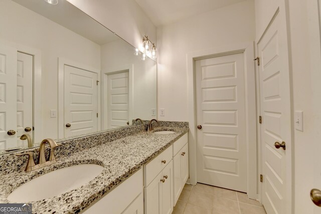 bathroom with double vanity, a sink, and tile patterned floors