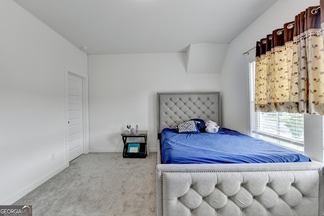 carpeted bedroom featuring multiple windows and baseboards