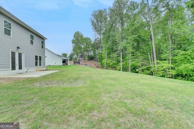 view of yard featuring a patio and french doors