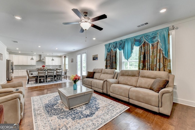 living room featuring recessed lighting, ceiling fan, baseboards, visible vents, and crown molding