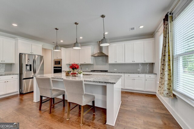 kitchen featuring tasteful backsplash, stainless steel appliances, white cabinets, dark wood-style flooring, and wall chimney exhaust hood