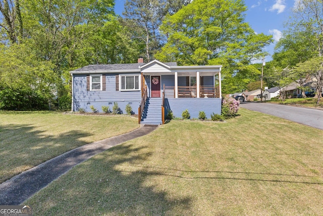 view of front facade with a chimney, a porch, a front lawn, and stairs