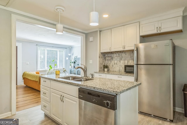 kitchen with white cabinets, tasteful backsplash, appliances with stainless steel finishes, and a sink