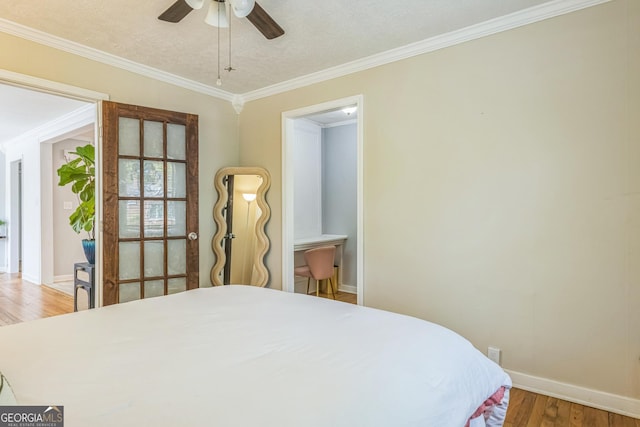 bedroom with ornamental molding, ceiling fan, wood finished floors, and baseboards
