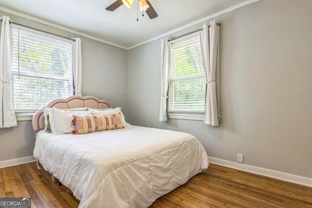 bedroom with ornamental molding, a ceiling fan, wood finished floors, and baseboards