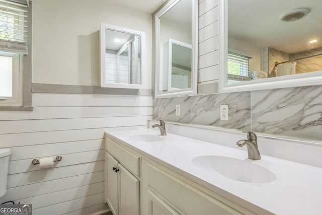 full bath with a shower with curtain, double vanity, and a sink