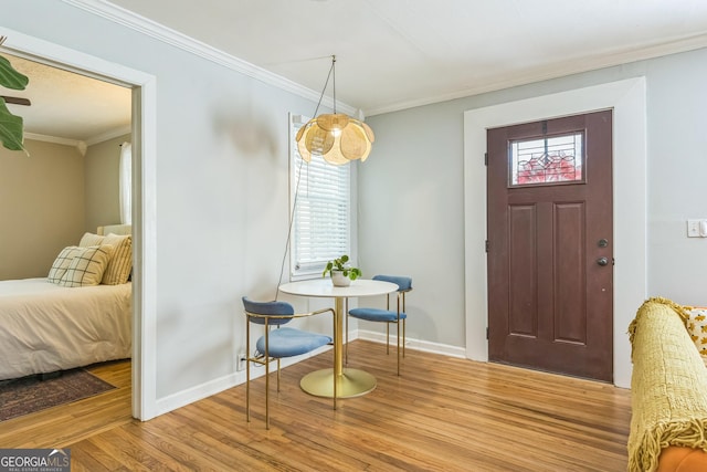 entryway featuring wood finished floors, a wealth of natural light, and ornamental molding