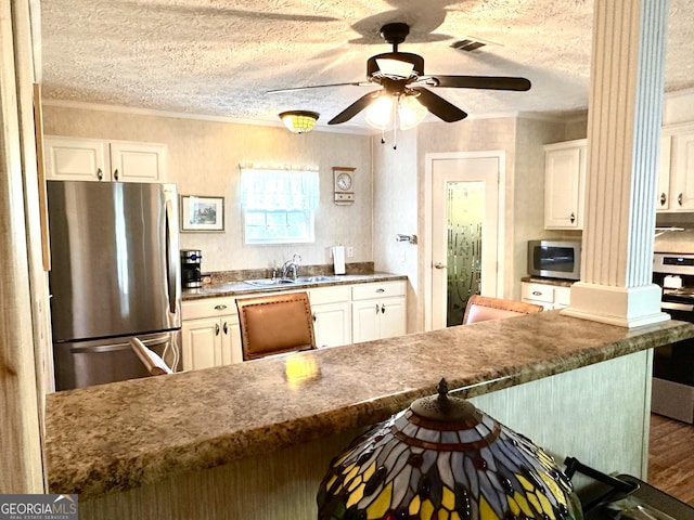 350 Kitty Hawk Ln, Clarkesville, GA 30523 - kitchen featuring ornamental molding, a textured ceiling, appliances with stainless steel finishes, and a breakfast bar area