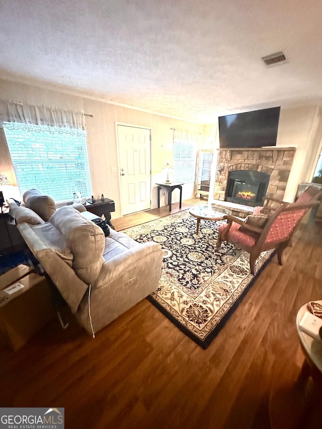 350 Kitty Hawk Ln, Clarkesville, GA 30523 - living area featuring visible vents, a textured ceiling, wood finished floors, and a stone fireplace