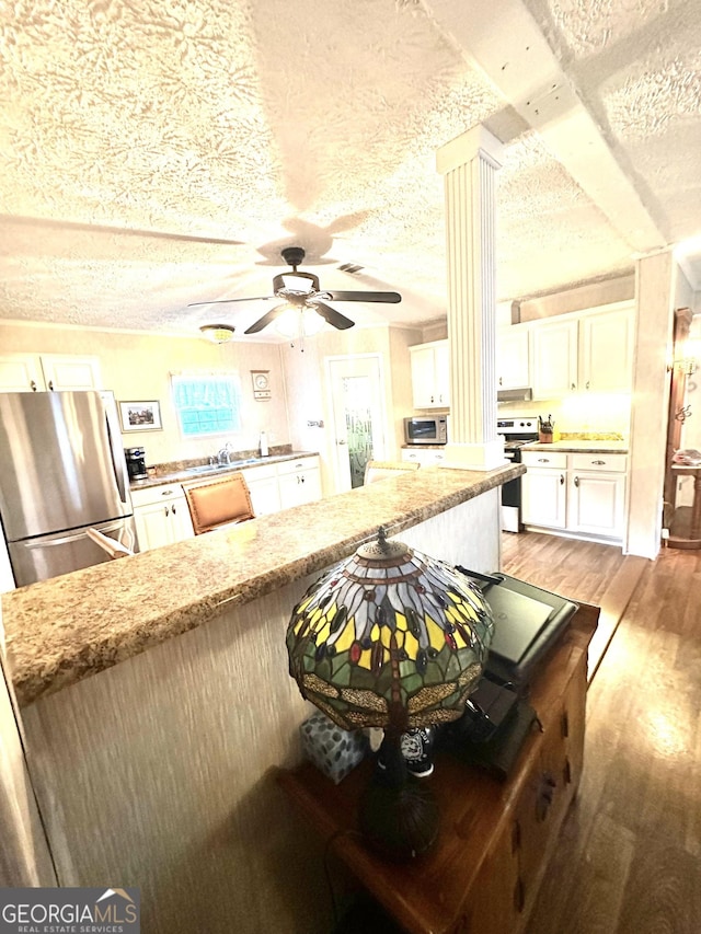 350 Kitty Hawk Ln, Clarkesville, GA 30523 - kitchen with white cabinets, appliances with stainless steel finishes, light stone counters, a textured ceiling, and light wood-type flooring