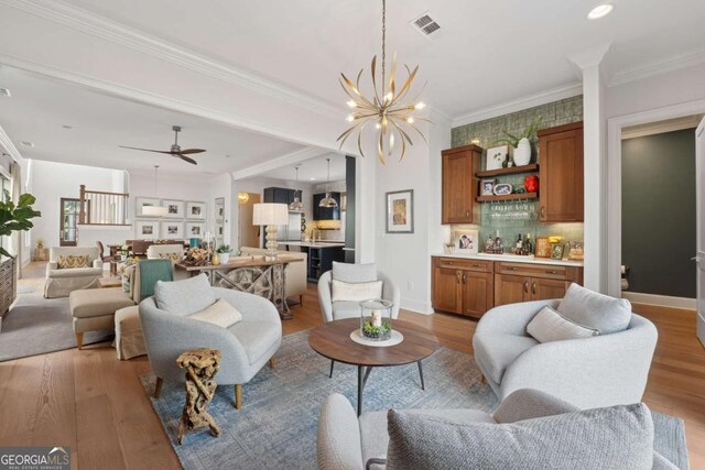 260 Jasmine Garden Way, Alpharetta, GA 30009 - living area with baseboards, ornamental molding, a dry bar, wood finished floors, and ceiling fan with notable chandelier